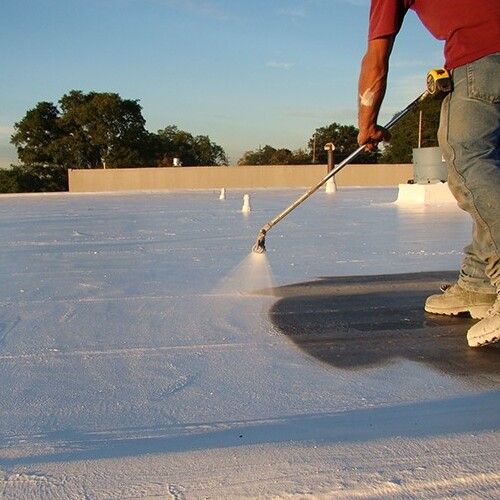 A Roofer Sprays on a Coating